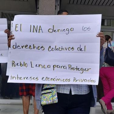 Mujer sostiene cartel